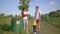 Family cleans nature, portrait of young happy volunteers father and mother with little daughter collects garbage in
