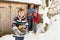 Family Collecting Logs From Wooden Store In Snow
