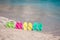 Family colorful flip flops on beach in front of the sea