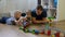 Family concept. Boys and dad playing with trains on wooden floor. Father with sons