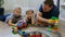 Family concept. Boys and dad playing with trains on wooden floor. Father with sons
