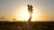 Family concept. Father and little daughter whirl in dance at sunset. Dad is dancing with a child in her arms in field in