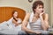 Family conflict. Young couple quarrels in bedroom at home.  Selective focus on man