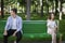 Family conflict. Young husband and wife sitting apart from each other on bench at park