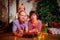 Family consisgitng mother, father and son in carnival costumes at Christmas or new year near the Christmas tree in the room. Mom,