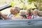 Family in convertible car smiling