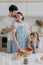 Family cook meal at home. Husband and wife embrace with love, small girl poses near, prepare delicious dinner, use milk, chocolate