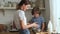 Family cooking in kitchen. Mother and son make pie cute boy looks at lady sieving flour