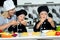 A family of cooks.Mother and children prepares spaghetti in kitchen.