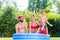 Family cooling down splashing water in garden pool