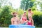 Family cooling down splashing water in garden pool