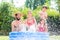 Family cooling down splashing water in garden pool