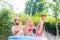 Family cooling down splashing water in garden pool