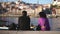 Family couple of traveling tourists sits together at Duero river quay in Porto.