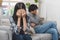 Family crisis. Asian wife crying on the sofa after husband cheating on her