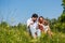 Family cuddling sitting on meadow