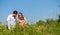 Family cuddling sitting on meadow