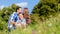 Family cuddling sitting on meadow in summer