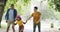 Family with cute adopted girl learning to roller skate with her parents. Young adoptive couple teaching foster daughter