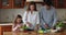 Family with cute little daughter prepare vegan dinner in kitchen