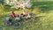Family cycling on bikes in spring aerial top view from above, happy active parents with children have fun and relax on grass