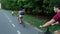 Family of cyclists biking on lane near forest in summer