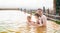 Family, dad and children bathe, swim in outdoor dirty hot springs. Thermal water bath pool and healthy natural, clay and