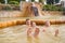 Family, dad and children bathe, swim in outdoor dirty hot springs. Thermal water bath pool and healthy natural, clay and