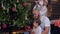 Family decorates christmas tree, two little girls with mother and father in xmas eve