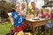 Family Decorating Easter Eggs On Table Outdoors