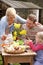 Family Decorating Easter Eggs On Table Outdoors