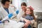 Family in dentistâ€™s office.dentist examining his girl patient in dentistâ€™s clinic