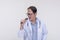 A family doctor singing with a microphone during a karaoke session after work. Of asian descent, middle aged male in his 40s.