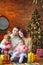 Family with dog sits on the floor near the festive Christmas tree