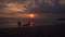 Family and dogs play on beach at sunset