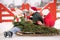 Family drinking tea to keep warm on a sleigh with a Christmas tree in a snowy winter outside