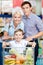 Family drives shopping trolley with food and son sitting there