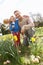 Family On Easter Egg Hunt In Daffodil Field