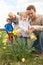 Family On Easter Egg Hunt In Daffodil Field