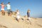 Family Enjoying Beach Holiday Running Down Dune