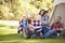 Family Enjoying Camping Holiday In Countryside