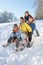 Family Enjoying Sledging Down Snowy Hill