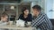 Family Enjoying tea In Cafe Together. Father and mother talking looking at their daughter.