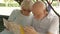 Family enjoying vacation. Seniors sitting on bench in park studying city map looking for showplaces