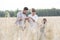 Family examining wheat crops at farm