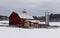 Family farm with red barn in a snowy winter background