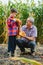 Family farming. Farmers grandfather with little grandson in a corn field. experienced grandfather explains grandson the nature of