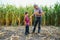 Family farming. Farmers grandfather with little grandson in a corn field. experienced grandfather explains grandson the nature of