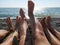 Family feet on a pebble beach by the sea