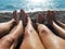 Family feet on a pebble beach by the sea